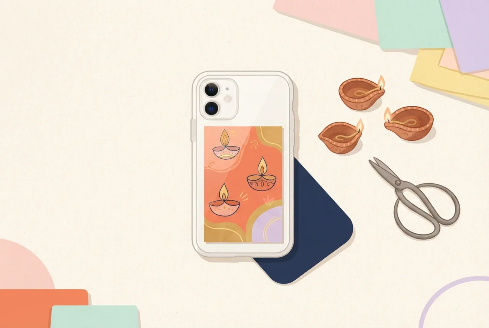 A clear phone case holding a warm orange and gold insert with hand-drawn oil lamps, next to a few real clay lamps and a pair of scissors